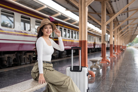 Young woman asian sitting and waiting for the train waiting for the train to go traveling. Travel...
