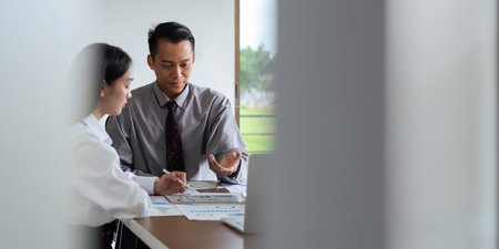 Asian business team meeting to analyze and discuss the situation on the financial report in the...