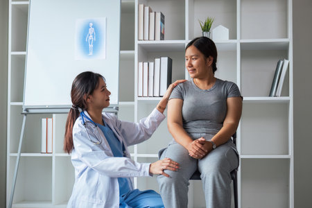 Overweight woman having consultation doctor at the clinic. portrait of friendly smiling doctor putting hand on shoulder supporting patient, giving consultation during medical examination in clinicの写真素材