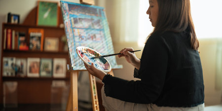 Close up of a creativity young woman artists hands painting vibrant strokes on a canvas in artistic...