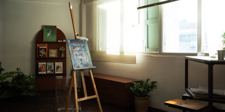 Unique artist workspace interior with bookcase, artworks, painting accessories, decoration and elegant personal stuff. Modern work room for artist.の写真素材