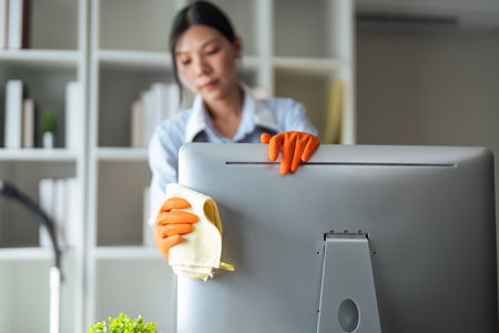 Asian woman cleaning in work room at home. Young woman housekeeper cleaner use a cloth to wipe equipment for working. concept housekeeping housework cleaningの写真素材