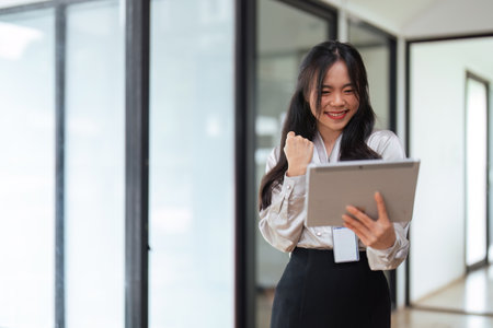Young women asian business worker looking at tablet discussing success corporate strategyの写真素材