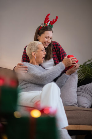 Caucasian Family, winter holiday and concept happy mother and daughter decorating christmas tree and give a gift at homeの写真素材