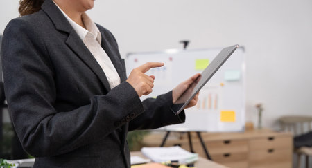 Young business woman executive worker holding digital tablet using pad technology device working in...