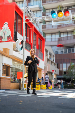 Asian professional businesswoman holding cellphone using smartphone standing or walking on big city...