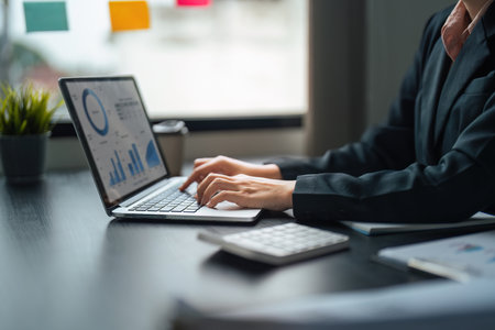 Young business woman looking at computer monitor, analyzing project statistics, marketing research results or statistics data, developing marketing strategy, working at officeの写真素材