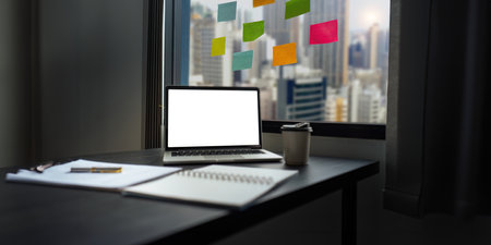 Use laptop with blank white screen mock up display for advertising text while working at her workplaceの写真素材