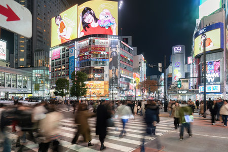 JAPAN - NOV 26, 2023 : Illumination of Advertising Signs at Night with Japanese people and Tourists walking across Shibuya Scramble Crossing, Shibuya, Tokyoのeditorial素材