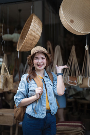 Young beautiful woman traveling at the local market during vacation. Tourist women travel enjoy shopping market during holidays, backpacker travellerの写真素材