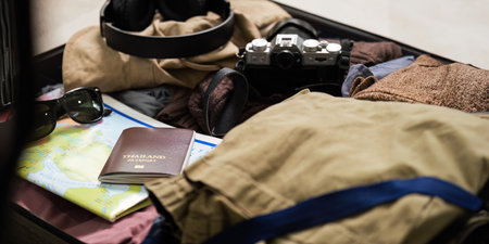 Pack prepare stuff and outfit clothes in suitcase travel bag luggage for summer, holiday, weekend, tour, journey, vacation trip at homeの写真素材