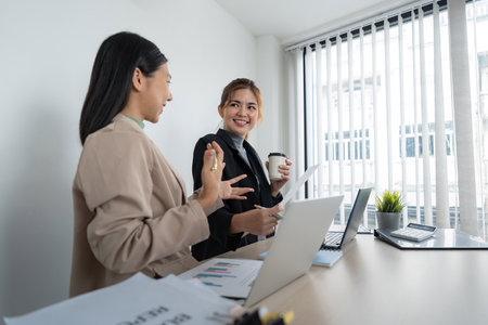 Business team two colleague are sitting at the meeting room and discuss chart and statisticsの写真素材