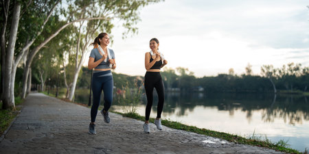 Healthy and active lifestyle, sport concept. Attractive ecstatic young sportswoman, smiling joyfully as jogging, sprinter run in parkの写真素材