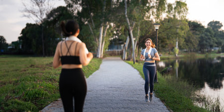 Jogging woman running in park on beautiful day off. Sport fitness model of asian ethnicity training outdoor for marathonの写真素材