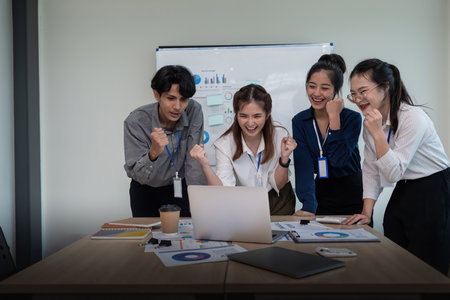 Business team celebrate corporate victory together in office, laughing and rejoicing, smiling excited employees colleague screaming with joy in officeの写真素材