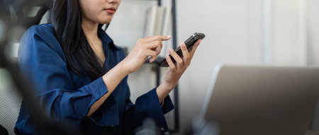 Young business woman on the phone at office. Business woman texting on the phone and working on...
