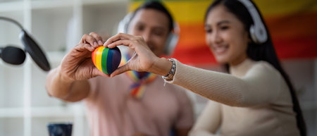 Young gay male and girl friend hands holding rainbow heart with smile face. LGBT, human rights and...