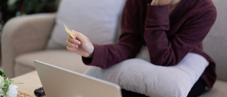 Young Asian woman hands holding credit card and using laptop for internet purchase. Online shopping, Online payment at homeの写真素材