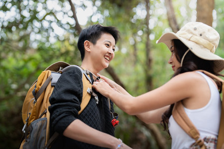 Lovely couple lesbian woman with backpack hiking in nature. Loving LGBT romantic moment in mountainsの写真素材