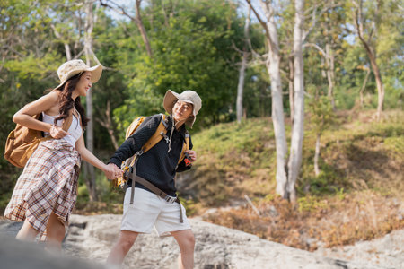Cheerful romantic lesbian couple traveler with backpack on their backs go hiking through the forest...