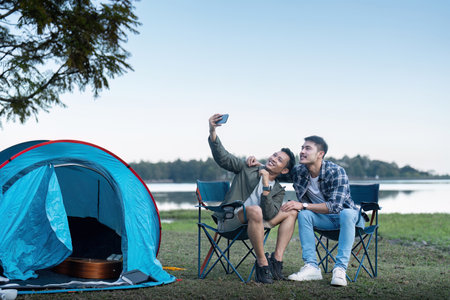 Happy Asian male gay couple on camping together in a forest. romantic vocation trip. lgbt concept