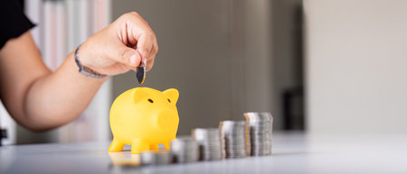 Woman hand putting coins in a piggy bank for save money and saving money concept