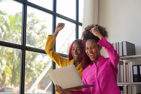 Two african woman celebrate when business goal success. achievement and business goal success...