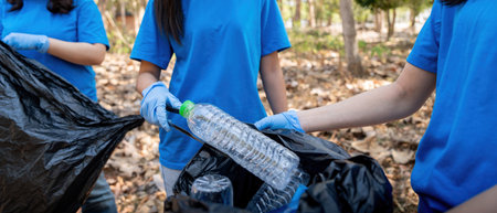 Young people friend volunteer collecting garbage plastic bottles to trash bags. environmental care...