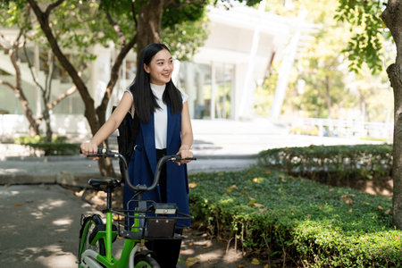 Asian businesswoman in bicycle go to work at office. Bike commuting, happy businesswoman using eco transport, Concept of eco lifestyleの写真素材
