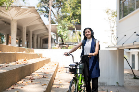 Eco friendly, Happy lifestyle asian beautiful young businesswoman riding bicycle go to office work...