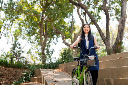 Eco friendly, Happy lifestyle asian beautiful young businesswoman riding bicycle go to office work...