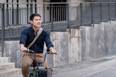 Eco friendly, Happy lifestyle asian young businessman ride bicycle go to office work at city street with bicycle in morningの写真素材
