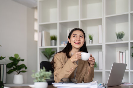 Work from home. Businesswoman using laptop computer in room. Eco friendly businesswoman working on desk with drink coffee in the morning, freelance, green room area, sustainable lifestyle conceptの写真素材