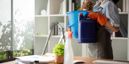 Young woman cleaning to disinfect the office office cleaning staff cleaning maid. Female cleaner...