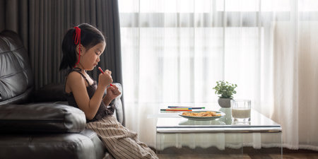 Happy child girl asian draw with colored pencil in living roomの写真素材