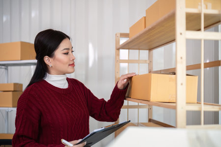 Woman asian in an online store check the customer address and package information on the laptop. Online shopping conceptの写真素材