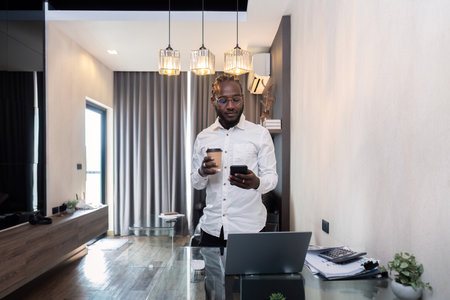 African American young man browsing internet on smartphone at home, African American young man read news check texting or messageの写真素材