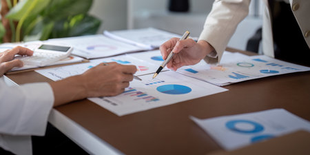 Business professionals discussing financial data and charts in an office. Concept of teamwork,...