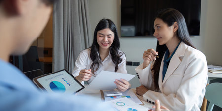Business Team Collaboration on Data Analysis in Modern Office Setting with Charts and Graphsの写真素材