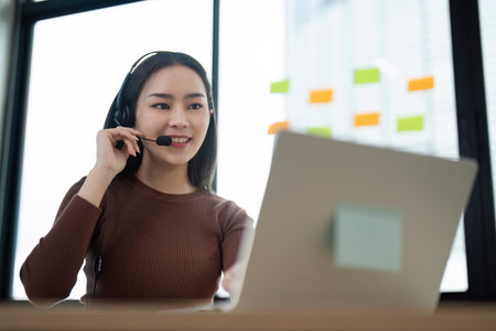 Professional Call Center Agent Working on Laptop with Headset in Modern Office Environment