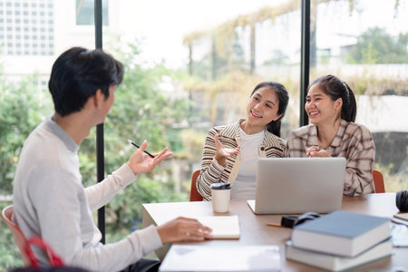 Diverse Group of Students Collaboration on a Project in a Modern Study Space with Natural Lightの写真素材
