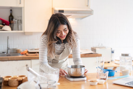 Smiling woman weighing ingredients in a modern kitchen