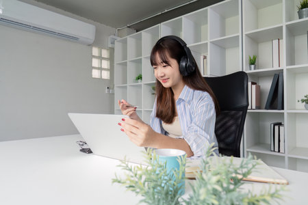 Focused Woman Engaging in Online Study Session at Homeの写真素材