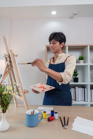 Young artist painting in a personalized studio spaceの写真素材