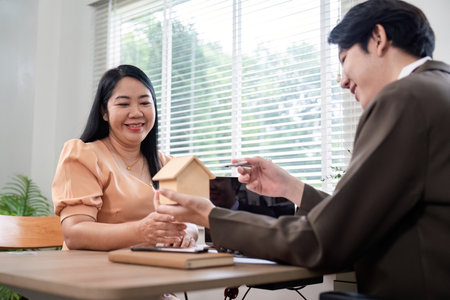 Client Deliberating Property Acquisition with Real Estate Agentの写真素材