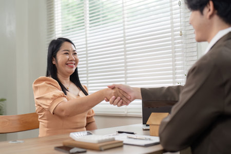 Smiling Client and Real Estate Agent Shaking Hands Post Deal Closure