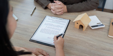 Property Manager Presenting Contract to Potential Homebuyerの写真素材