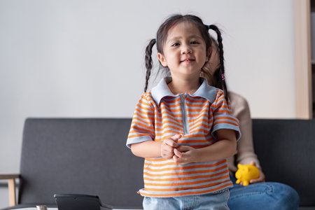Young Daughter Engaged in Financial Education with Supportive Motherの写真素材