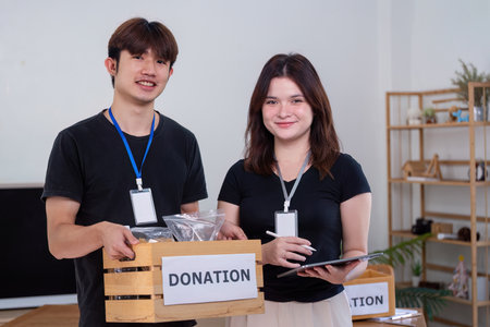 Happy Volunteers Smiling with Donation Box Indoors