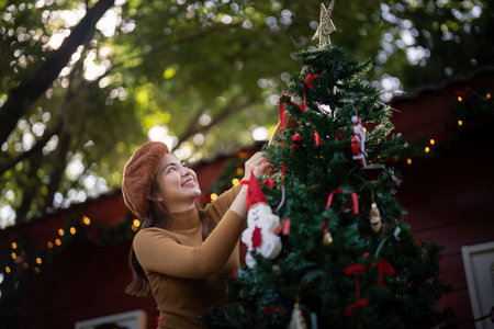 Festive Enthusiast Decorating Christmas Tree During Holiday Seasonの写真素材